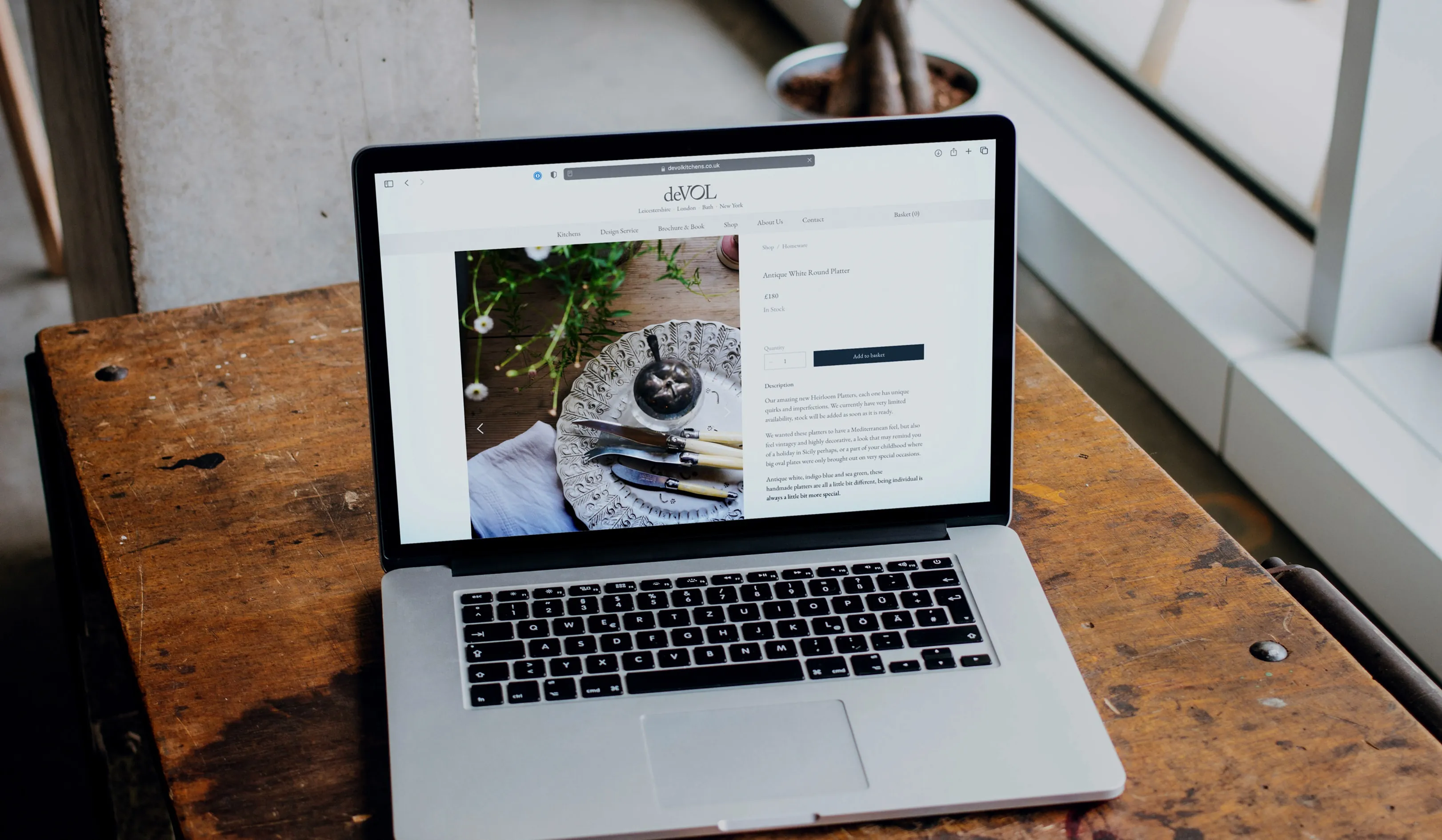 deVOL product page on a laptop sitting on a rustic work bench